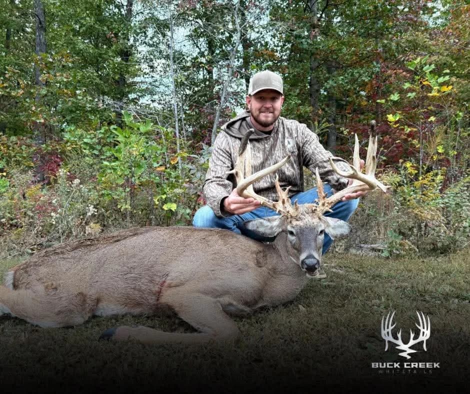 Hunter with a trophy whitetail in the woods