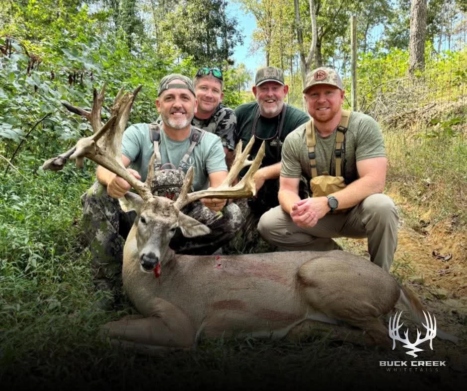 A group of Buck Creek hunters with a trophy whitetail